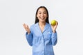 Morning, active and healthy lifestyle and home concept. Excited asian girl in blue pajamas looking happy, smiling as Royalty Free Stock Photo