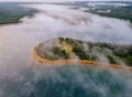 Morning aerial view of lake with fog above water surface and sunrise over forest Royalty Free Stock Photo