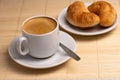 Morning aromatic coffee with two fresh croissants on a white plate on a napkin made of natural bamboo Selective focus Royalty Free Stock Photo