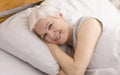 Portrait of cheerful senior woman resting in bed Royalty Free Stock Photo