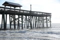 Waves crash the beach pier pilings and then onto the sandy shoreline off the Atlantic Seaboard.