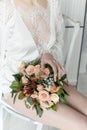 Morning beautiful delicate bride with short hair with a small wreath silk underwear sitting on a chair with a wedding bouquet Royalty Free Stock Photo