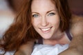 Morning in bed, a young charming red-haired woman with freckles lying in bed, hugging pillow, smiling, enjoying the Royalty Free Stock Photo