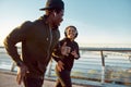 Morning is the best time for jogging. Young happy african couple or friends wearing headphones running together on the Royalty Free Stock Photo