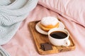 Morning breakfast in bed with fresh and hot bracing coffee, a doughnut in powdered sugar and three slices of chocolate Royalty Free Stock Photo