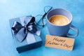 Morning breakfast with coffee, gift box, greeting card on Happy Fathers Day and eyeglasses on blue table. Royalty Free Stock Photo