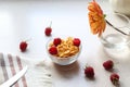 Morning Breakfast of cornflakes and raspberries on the kitchen table with a bouquet and napkin, side view-quick Breakfast concept