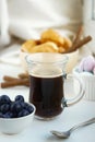 morning Breakfast Cup of coffee, croissants, colored sweet meringues, blueberries in a clay white glass