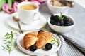 Morning breakfast with cup of coffee, croissants, fresh berries and pink flowers tulips Royalty Free Stock Photo