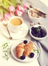 Morning breakfast with cup of coffee, croissants, fresh berries and pink flowers tulips Royalty Free Stock Photo