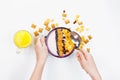 Morning breakfast. Female hands hold a spoon over a bowl with homemade yogurt and cornflakes, raisins, almonds on white background Royalty Free Stock Photo