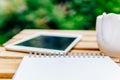 Morning Breakfast In Green Garden With French Croissant, Coffee Cup, Orange Juice, Tablet and Notes Book On Wood Table Royalty Free Stock Photo