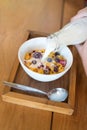 Morning breakfast, little girl hand with cornflakes cereal, strawberry, blackberry and milk in a white bowl Royalty Free Stock Photo