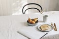 Morning breakfast with pears fruit composition. Bread toast, folded newspapers and dry grass in mug on white linen table