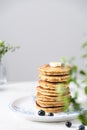 Morning breakfast table, stack of pancakes with blueberries, piece of butter and honey