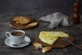 Morning breakfast of a traditional French omelet with toasts and butter and a white porcelain cup of coffee on a wooden board Royalty Free Stock Photo