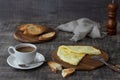 Morning breakfast of a traditional French omelet with toasts and butter and a white porcelain cup of coffee on a wooden board Royalty Free Stock Photo