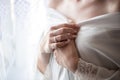 Morning bride. A beautiful girl with a white veil on her head stands near the window. Wedding portrait for the bride. Boudoir