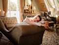 morning of bride. beautiful woman in lace robe lies on couch in room. Royalty Free Stock Photo