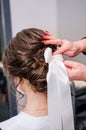 The morning of the bride. Girl makes a stylish hairstyle, a friend helps the bride, a beautiful hair ornament