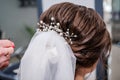 The morning of the bride. Girl makes a stylish hairstyle, a friend helps the bride, a beautiful hair ornament