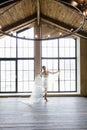 Morning of the bride. A gorgeous bride, a beautiful woman with long hair in a white robe at the window with a veil in her hands. Royalty Free Stock Photo