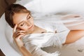 Morning of the bride. Happy beautiful young woman is wearing in a white long veil, robe and underwear sitting laughing Royalty Free Stock Photo