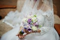 Morning of the bride preparation. Young and handsome bride at wedding day. Bouquet at hands