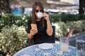 Morning in cafÃÂ© - attractive woman in black dress and dark sunglasses drinking coffee and make selfie photo for social networks Royalty Free Stock Photo