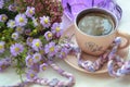Morning hot coffe in cup and little violet flowers on white wooden table