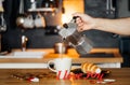 Morning coffee for the beloved. Male hand on the background of home cooking with a warm light, pours coffee in a mug of nightingal Royalty Free Stock Photo