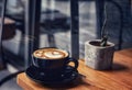 Morning coffee in a black cup on wooden table Royalty Free Stock Photo