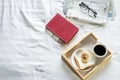 Morning coffee bread and book or newspaper on the bed. Royalty Free Stock Photo