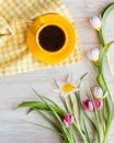 Morning coffee in bright yellow cup, napkin. Fresh garden pink and white tulips, Royalty Free Stock Photo