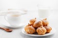 Morning coffee with cakes. Profiteroles, coffee, cream on a white wooden table