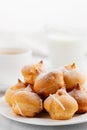 Morning coffee with cakes. Profiteroles, coffee, cream on a white wooden table. Vertical image