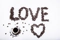 Inscription made of coffee beans on white background next to a cup of coffee Royalty Free Stock Photo