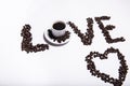 Inscription made of coffee beans on white background next to a cup of coffee Royalty Free Stock Photo