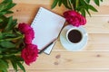 Morning coffee cup for breakfast, empty notebook and red peony flowers