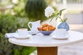 Morning coffee with fresh pastries and news in the newspaper in the fresh air on the terrace by the house. Plate with pastries,