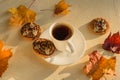 Morning coffee with Halloween cookies and maple leaves on light concrete background. Halloween concept. Fall time