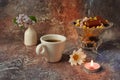 Morning coffee in a hurry: a cup of coffee, flowers in a vase, dried fruits and sweets in a vase, a burning candle Royalty Free Stock Photo