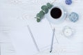 Morning coffee mug for breakfast, empty notebook, pencil and flowers on white table top. Woman working desk.