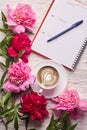 Morning coffee mug for breakfast, empty notebook, pencil and pink peony flowers Royalty Free Stock Photo