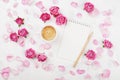 Morning coffee mug for breakfast, empty notebook, petal and pink rose flowers on white table top view in flat lay style. Royalty Free Stock Photo
