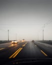 Point of view: driving along a bridge on a cloudy day. Royalty Free Stock Photo