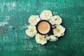 Morning cup of coffee and beautiful roses flowers on teal rustic table top view. Cozy Breakfast. Flat lay style.