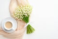 Morning cup of coffee and bouquet of flowers lily of the valley on white table from above. Beautiful breakfast for Morthers or Royalty Free Stock Photo