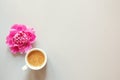 Cup of coffee and fresh beautiful spring pink peony flower on light background, top view, flat layout, copy space