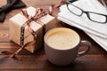 Morning cup of coffee, gift, newspaper, glasses and bowtie on wooden desk for breakfast on Happy Fathers Day
